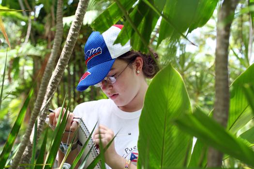 A girl writing in a journal outdoors